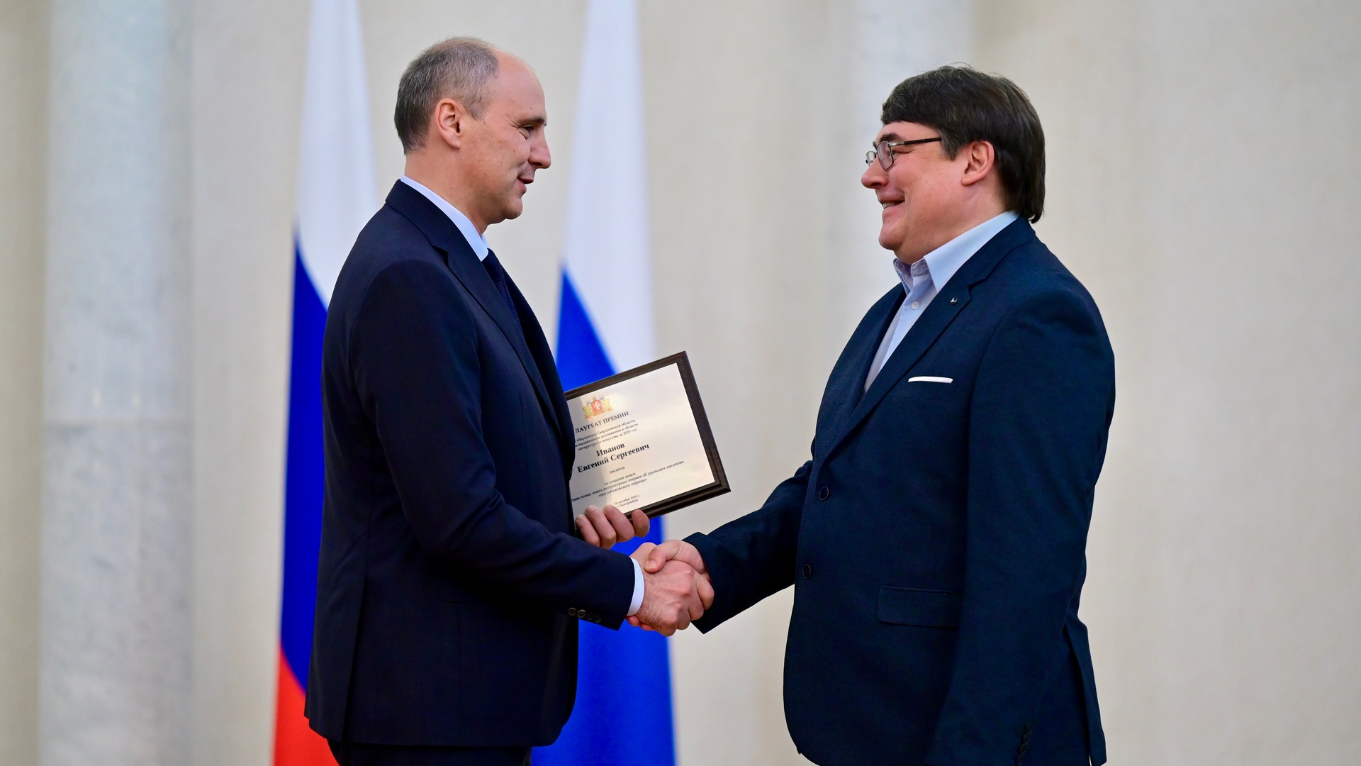 Денис Паслер вручает награду Евгению Иванову
