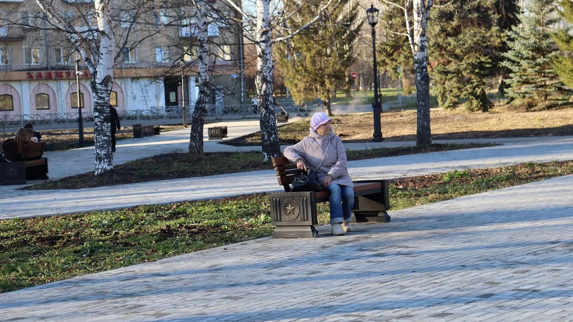 Женщина сидит на скамейке в сквере Труда и Победы в Верхней Салде.